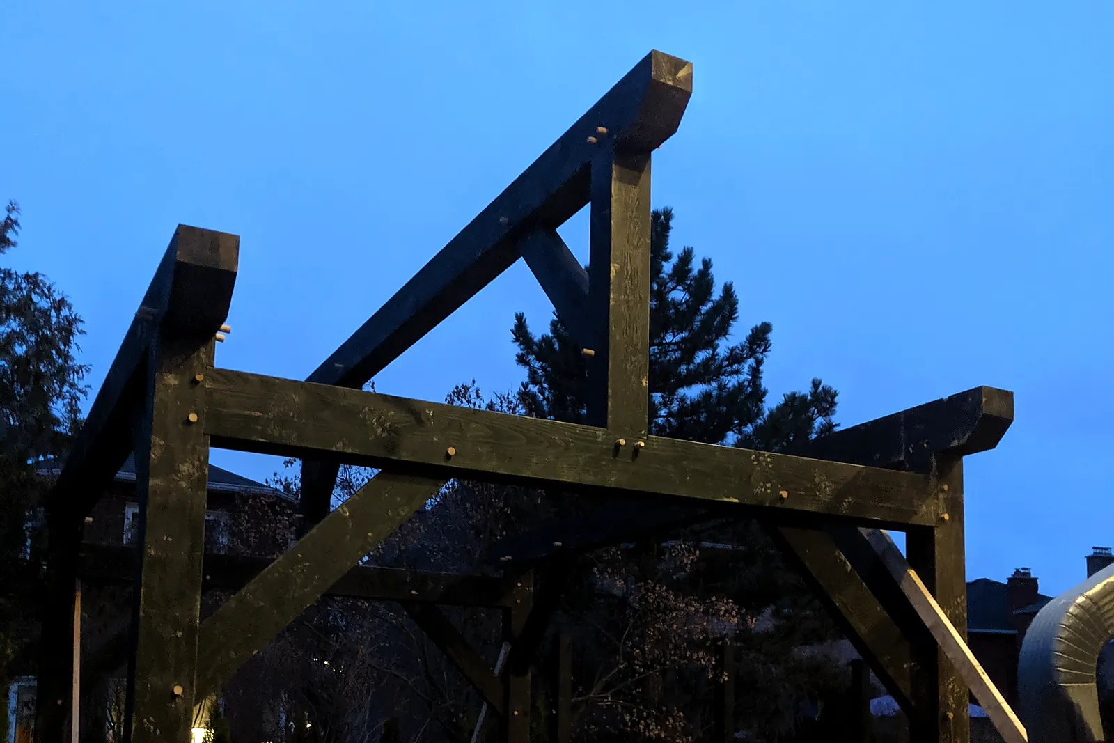 Felállított timber frame keretállás (bent) Oakville-ben, Kanadában, nagy keresztmetszetű faelemekkel és könyökfákkal